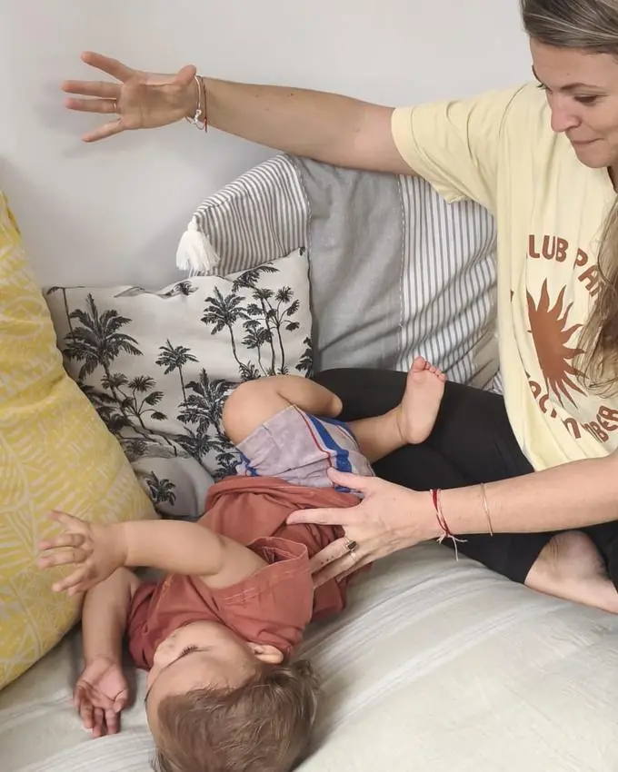 Accompagnement du mouvement d'un jeune enfant allongé, geste d'ouverture guidé