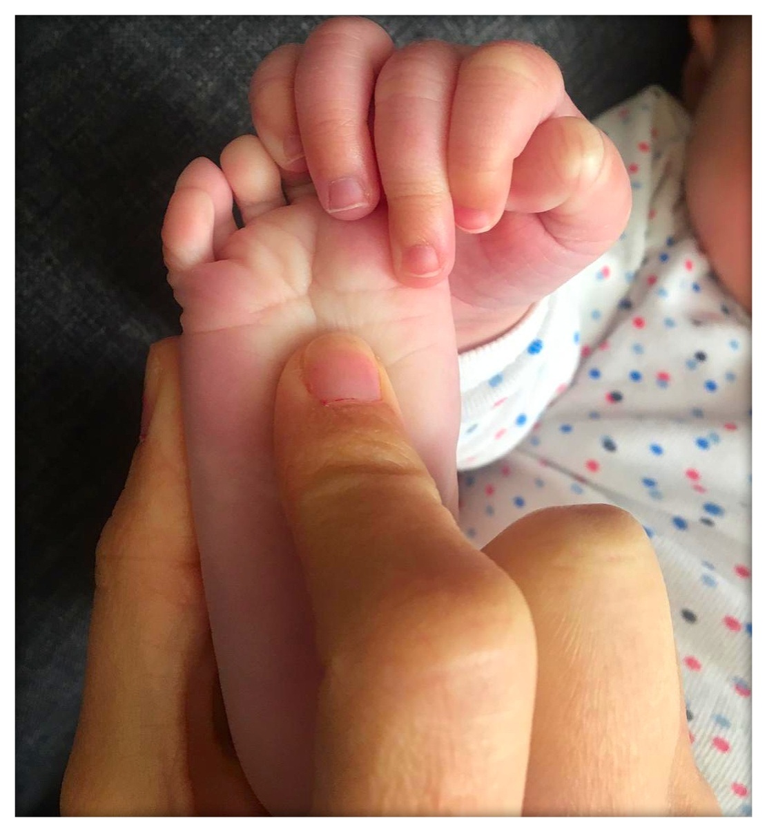 main massant un pied de bébé